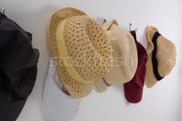 Various straw hats and caps hanging on hook Stock photo © wavebreak_media