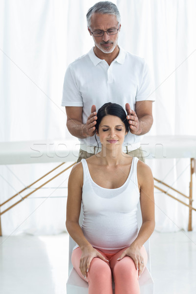 Pregnant woman receiving a head massage from masseur Stock photo © wavebreak_media