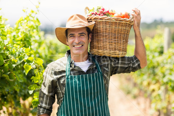 Portrait of happy farmer carrying a basket of vegetables Stock photo © wavebreak_media