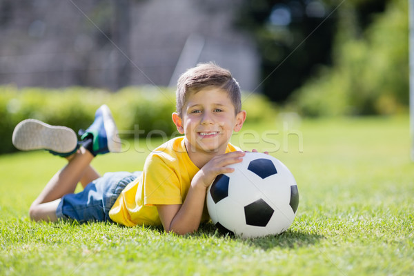 Boy lying on grass with football in the park Stock photo © wavebreak_media