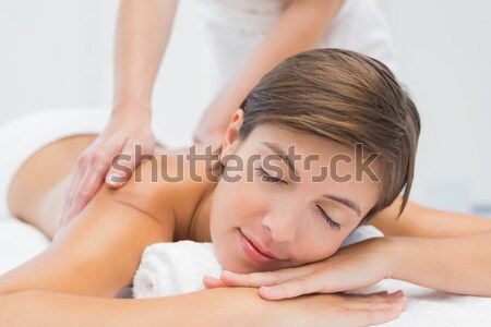 Beautiful brunette getting a massage while lying down in a spa centre Stock photo © wavebreak_media