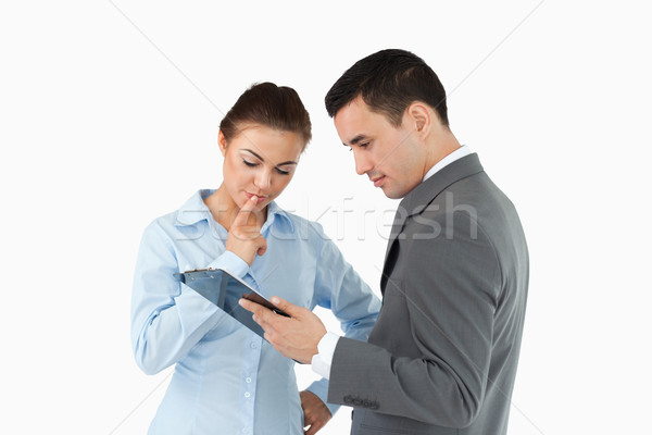 Business partners analyzing document on the clipboard against a white background Stock photo © wavebreak_media