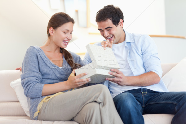 Stock photo: Man surprising his fiance with a present in their living room