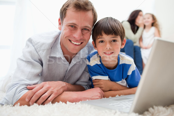 Uśmiechnięty syn tata za pomocą laptopa wraz dywan Zdjęcia stock © wavebreak_media