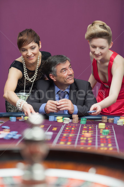 Woman placing bet for man at roulette in casino Stock photo © wavebreak_media