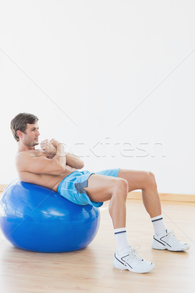 Shirtless man exercising on fitness ball in gym Stock photo © wavebreak_media