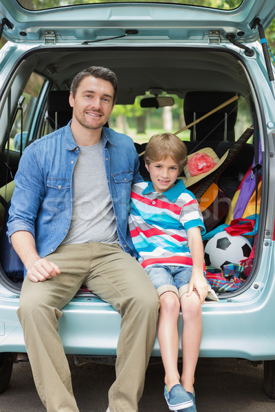 Portrait of father and son sitting in car trunk Stock photo © wavebreak_media