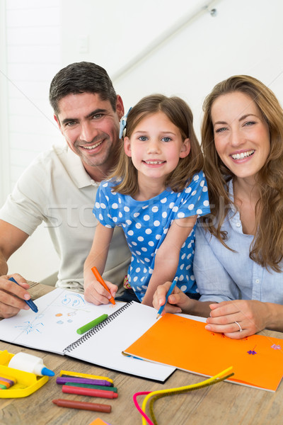 Stock photo: Happy daughter and parents coloring