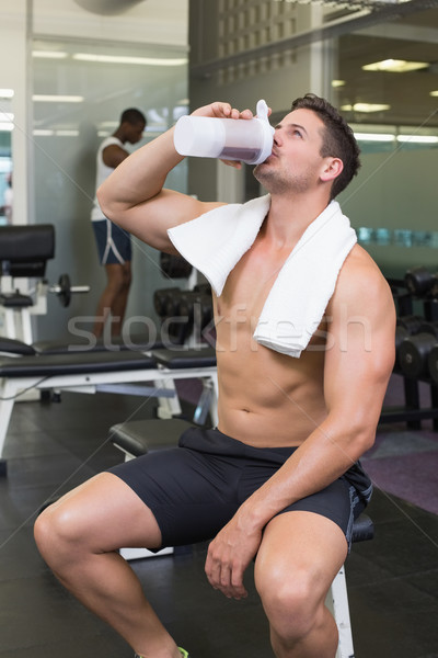 Shirtless bodybuilder drinking protein drink sitting on bench Stock photo © wavebreak_media