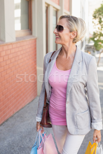 Stock photo: Happy mature woman walking with her shopping purchases