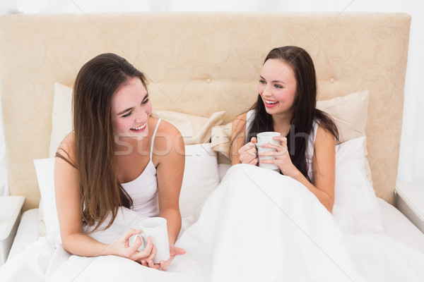Pretty friends having coffee in bed Stock photo © wavebreak_media