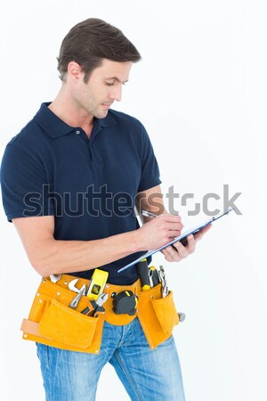 Man with tool belt around waist pointing against white backgroun Stock photo © wavebreak_media