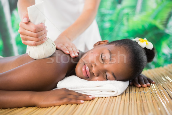 Stock photo: Pretty woman enjoying a herbal compress massage