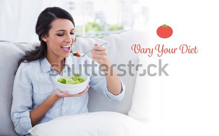 Smiling beautiful brunette relaxing on the couch and eating sala Stock photo © wavebreak_media