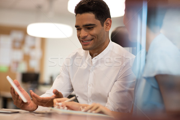 Smiling businessman discussing with female colleague on digital tablet Stock photo © wavebreak_media