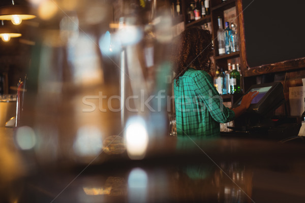 Female bar tender using electronic machine Stock photo © wavebreak_media