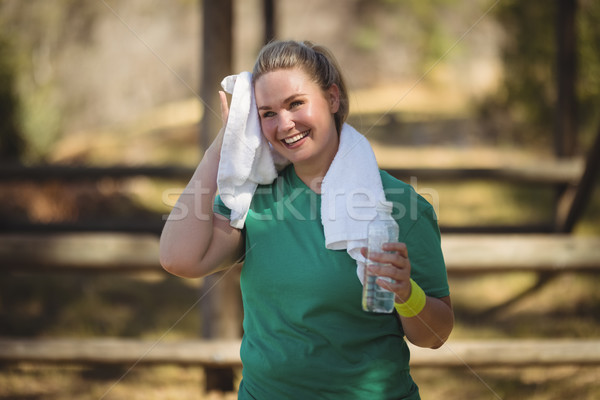 Happy woman wiping sweat with towel after workout Stock photo © wavebreak_media
