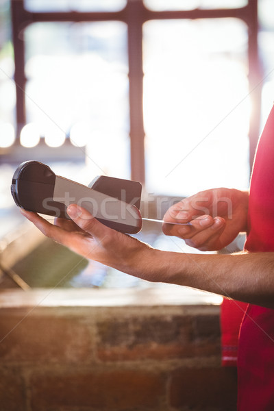Stock photo: Waiter inserting customer's credit card into credit card machine