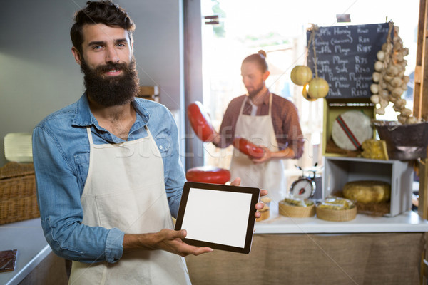 Portrait of smiling staff showing digital tablet at counter Stock photo © wavebreak_media