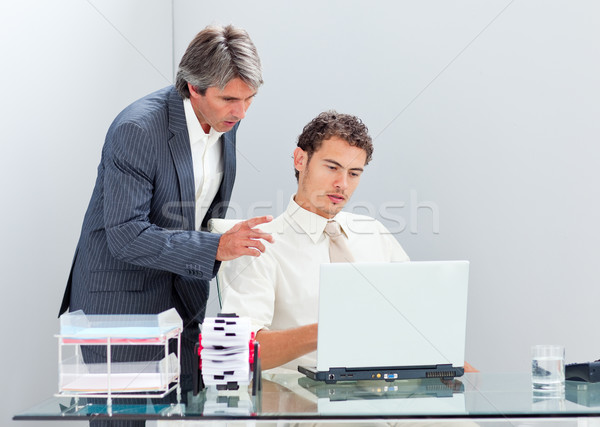 Stock photo: Concentrated manager helping his colleague work at a computer