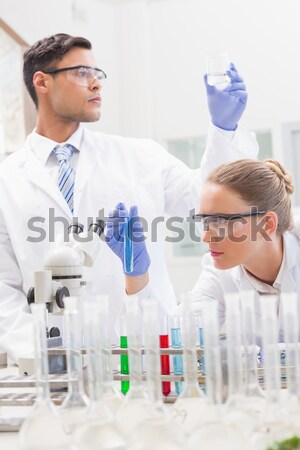 Gorgeous female biologist holding a manual pipette with sample from test tubes in a lab Stock photo © wavebreak_media