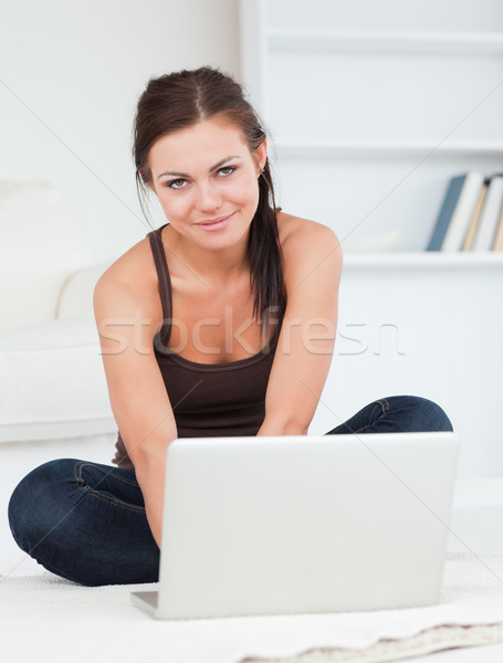 Beautiful dark-haired woman using her laptop in her livng room Stock photo © wavebreak_media