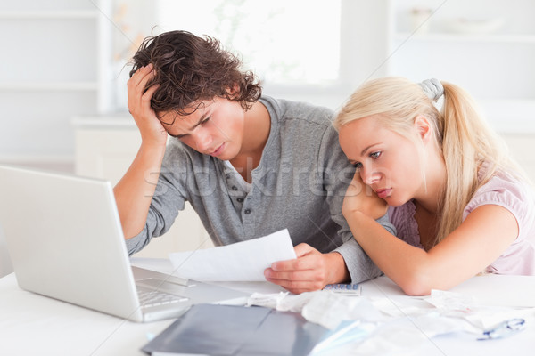 Stock photo: Tired couple doing their accounts in their living room