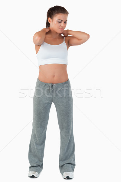 Stock photo: Young female experiencing pain in her neck against a white background