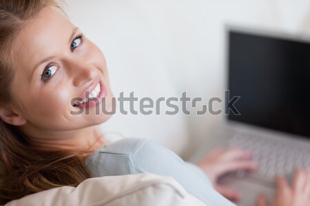 Shadowing young woman with laptop on the sofa Stock photo © wavebreak_media