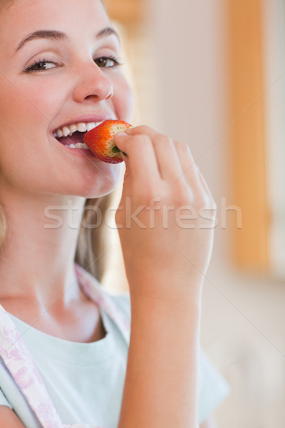 Close up of a woman eating a strawberry while looking at the camera Stock photo © wavebreak_media