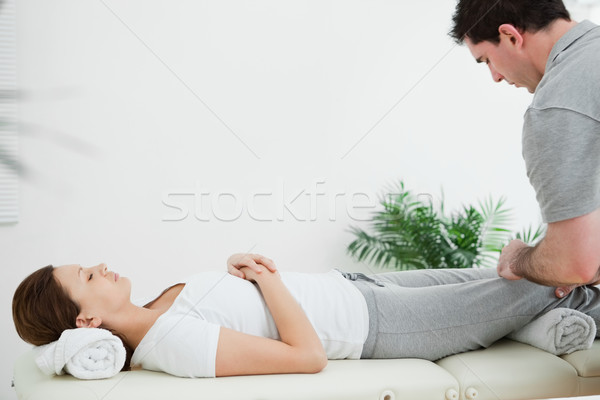 Stock photo: Brunette woman lying while being massaging by a man