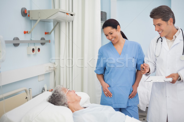 Doctor and nurse smiling to a patient in hospital ward Stock photo © wavebreak_media