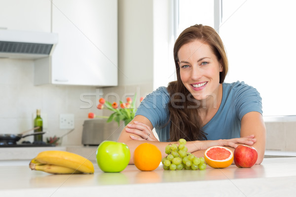 Smiling woman with fruits on kitchen counter Stock photo © wavebreak_media