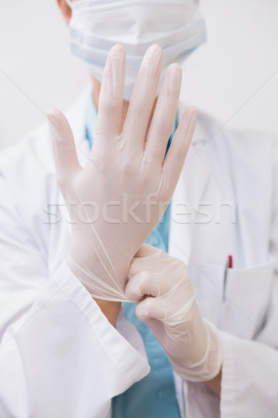 Dentist pulling on surgical gloves Stock photo © wavebreak_media