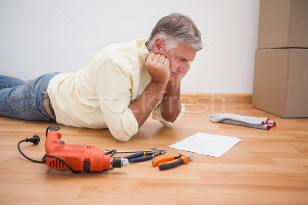 Man lying on floor reading tool instructions Stock photo © wavebreak_media