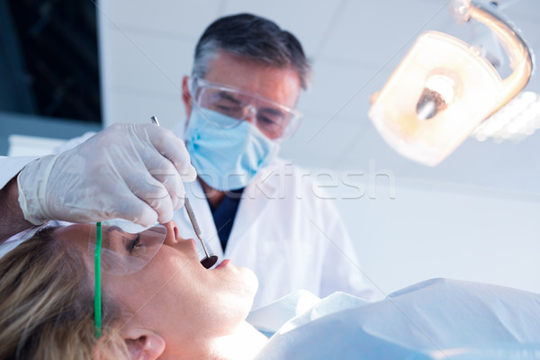 Dentist examining a patients teeth under bright light Stock photo © wavebreak_media