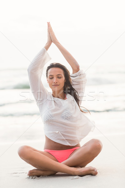 Brunette vergadering lotus pose strand Stockfoto © wavebreak_media