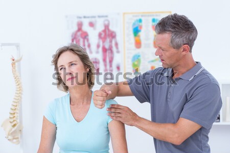 Doctor stretching his patients arm Stock photo © wavebreak_media