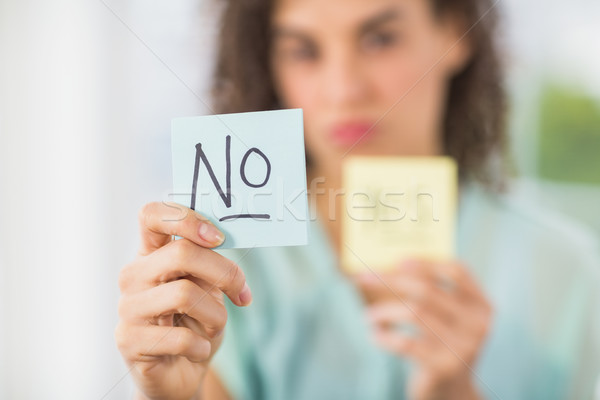 Stock photo: Smiling businesswoman holding yes and no sticks