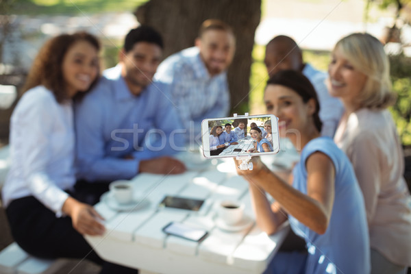 Grupo amigos toma teléfono móvil aire libre restaurante Foto stock © wavebreak_media