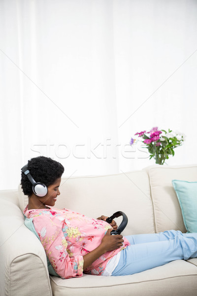 беременная женщина наушников живота диване женщину Сток-фото © wavebreak_media