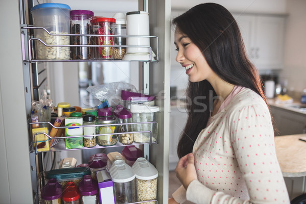 Zdjęcia stock: Młoda · kobieta · patrząc · przechowywania · szafka · kuchnia · domu