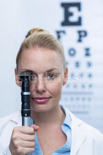 Female optometrist looking through ophthalmoscope Stock photo © wavebreak_media