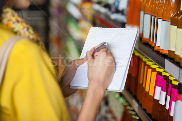 Vrouw kruidenier schrijven notepad supermarkt Stockfoto © wavebreak_media