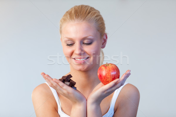 Friendly woman holding chocolate and apple focus on woman  Stock photo © wavebreak_media