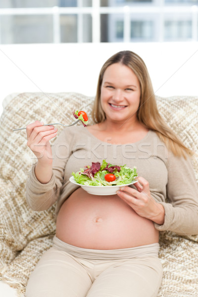 Femme enceinte manger légumes salon sourire [[stock_photo]] © wavebreak_media