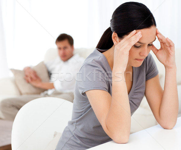 Man looking at his girlfriend having a headache sitting at a table in the living room  Stock photo © wavebreak_media