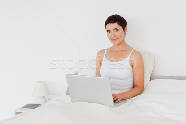 Bájos nő laptopot használ néz kamera számítógép Stock fotó © wavebreak_media