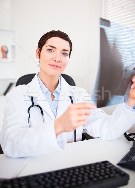 Stock photo: Portrait of a doctor holding a set of X-ray while looking at the camera