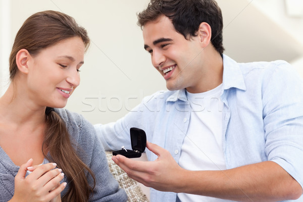Stock photo: Happy man proposing marriage to his girlfriend in their living room